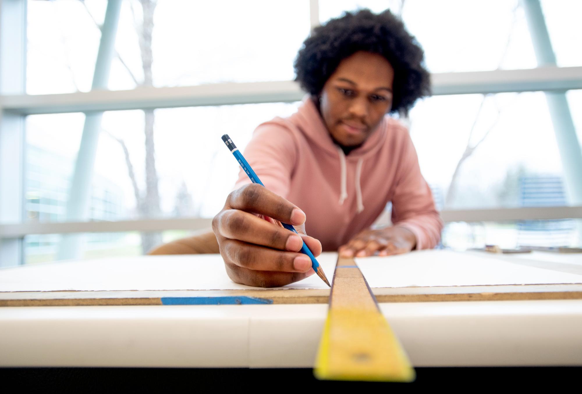 Student in an Introduction to Drawing class getting ready to practice perspective drawing
